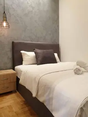 a bedroom with a large bed with white sheets at Apartment Theatre in Belgrade