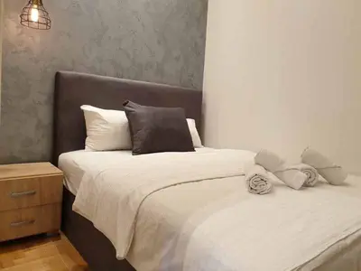 a bedroom with a bed with white sheets and pillows at Apartment Theatre in Belgrade