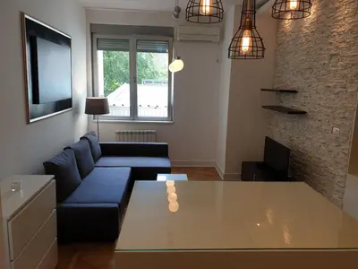 a living room with a blue couch and a table at Apartment Theatre in Belgrade