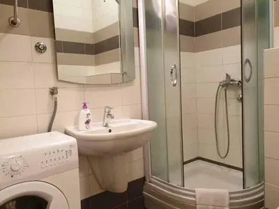 a bathroom with a sink and a shower and a washing machine at Apartment Theatre in Belgrade