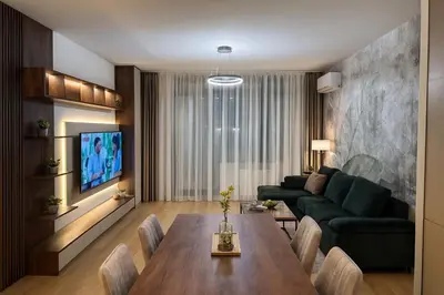 a living room with a table and a green couch at Belgrade Waterfront Premium LuX Apartment in Sajmište