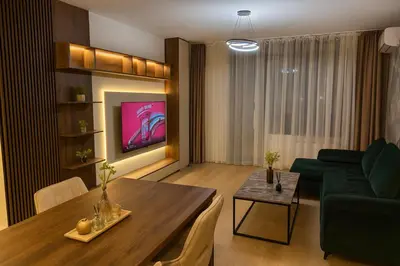 a living room with a table and a green couch at Belgrade Waterfront Premium LuX Apartment in Sajmište