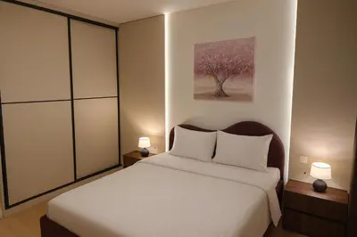 a bedroom with a bed with two lamps and a tree at Belgrade Waterfront Premium LuX Apartment in Sajmište