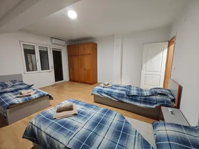 a room with three beds in a room at Čiča 1 in Dobanovci