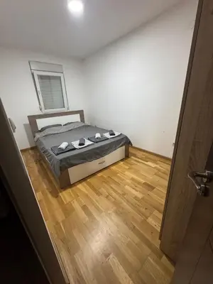 a bedroom with a bed and a wooden floor at D2Apartman 1 in Belgrade