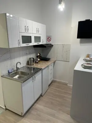 a small kitchen with white cabinets and a sink at Sofija in Belgrade