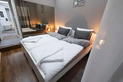 a large white bed in a room with a couch at Beo City Apartmani in Belgrade