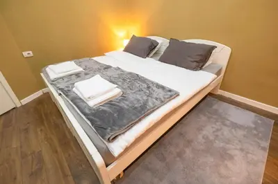 a bed with white blankets and pillows on it at Beo City Apartmani in Belgrade