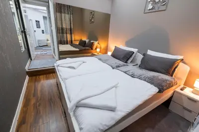 a large white bed in a room with a mirror at Beo City Apartmani in Belgrade