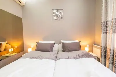 a bedroom with two beds with white sheets and gray pillows at Beo City Apartmani in Belgrade