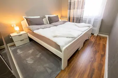 a bedroom with a white bed with a window at Beo City Apartmani in Belgrade