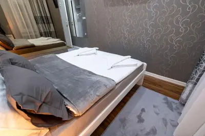 a bed in a room with a mirror at Beo City Apartmani in Belgrade