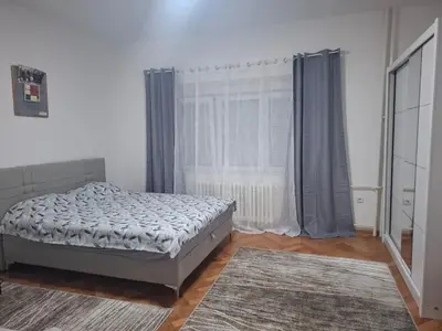 a bedroom with a bed and a large window at Paviljoni apartman in Tošin Bunar