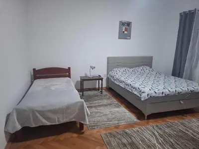 a bedroom with two twin beds and a table at Paviljoni apartman in Tošin Bunar