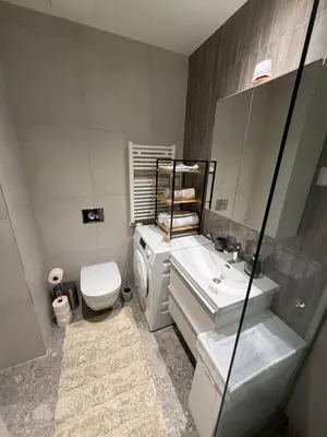 a bathroom with a sink and a toilet and a mirror at Belgrade Waterfront luxury apartment & free parking in Belgrade