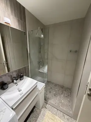 a bathroom with a white sink and a shower at Belgrade Waterfront luxury apartment & free parking in Belgrade