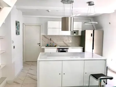 a kitchen with white cabinets and a white refrigerator at Luxure Suites in Belgrade
