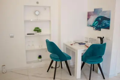 a room with a table and two blue chairs at Luxure Suites in Belgrade