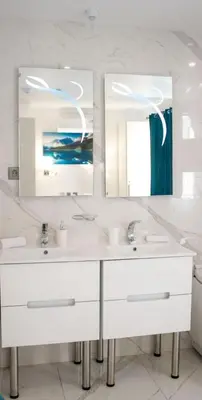 a bathroom with two sinks and a large mirror at Luxure Suites in Belgrade