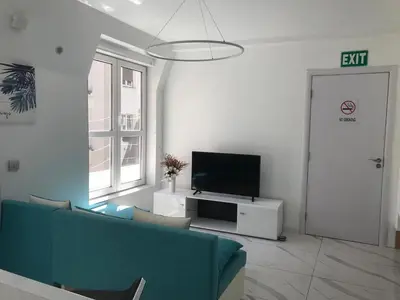 a living room with a couch and a flat screen tv at Luxure Suites in Belgrade
