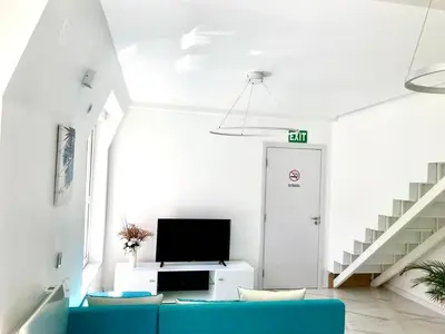 a living room with a blue couch and a tv at Luxure Suites in Belgrade