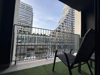 a chair on a balcony with a view of a building at Belgrade Waterfront Apartments 3 in Belgrade