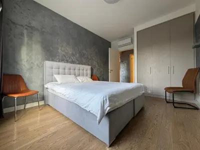a bedroom with a large bed and two chairs at Belgrade Waterfront Apartments 3 in Belgrade