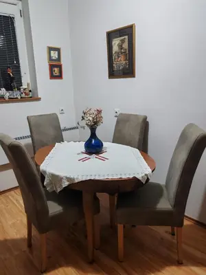 a dining room table with four chairs and a vase on it at Signorina in Smederevo