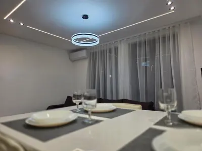a dining room with a table with plates and wine glasses at Masa in Arandjelovac