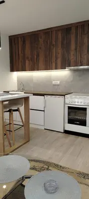 a kitchen with white cabinets and a table and a stove at Masa in Arandjelovac