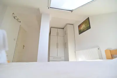 a bedroom with a white bed and a skylight at Botanical Hideout - Near Botanical Garden & City Center in Belgrade