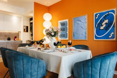 a dining room with a table and blue chairs at WF Sky Charm with Terraces & Billiard in Belgrade