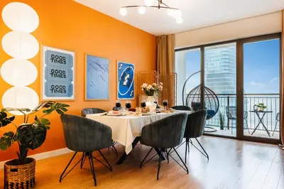 a dining room with orange walls and a table and chairs at WF Sky Charm with Terraces & Billiard in Belgrade