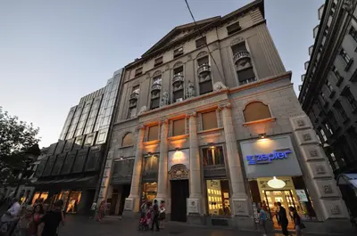 a large building with people walking in front of it at White Gallo Residences in Belgrade