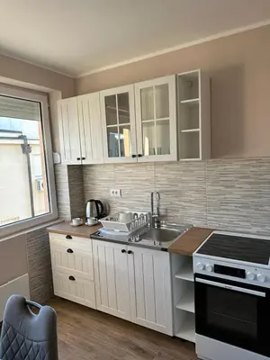 a kitchen with white cabinets and a sink at Vojvoda Apartment in Belgrade