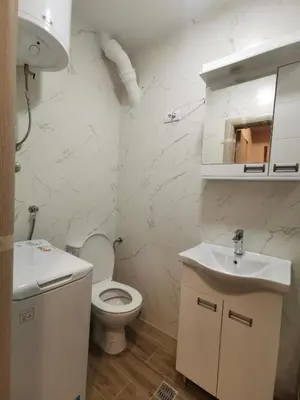 a white bathroom with a toilet and a sink at Vojvoda Apartment in Belgrade