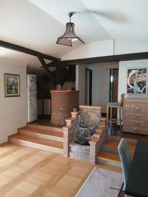 a living room with stairs and a stone fireplace at Villa Atlantis in Guncati