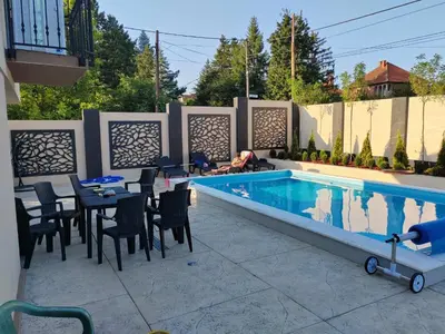 a swimming pool with tables and chairs next to a swimming pool at Villa Atlantis in Guncati