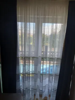 a window with white curtains in a room at Villa Atlantis in Guncati
