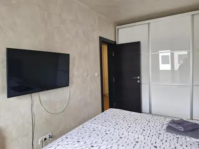 a bedroom with a bed with a flat screen tv on the wall at Kolet Zemun in Belgrade
