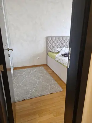 a small bedroom with a bed and a rug at Kolet Zemun in Belgrade