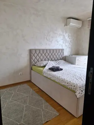 a bedroom with a bed in a room with a rug at Kolet Zemun in Belgrade