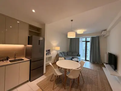 a kitchen and living room with a table and a couch at BW Maca - Aurora in Belgrade