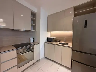 a kitchen with white cabinets and a stainless steel refrigerator at BW Maca - Aurora in Belgrade