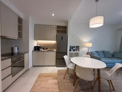 a kitchen and living room with a table and a couch at BW Maca - Aurora in Belgrade