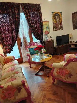 a living room with chairs and a table and a tv at Apartment Kalis in Belgrade