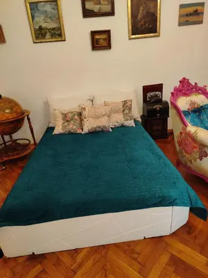 a bedroom with a bed with a green blanket at Apartment Kalis in Belgrade