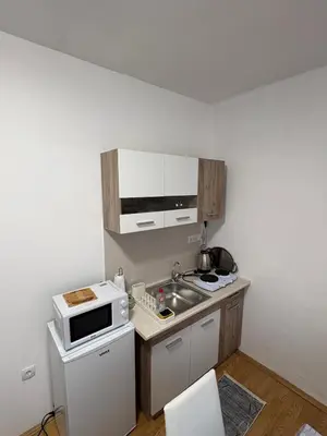 a small kitchen with a sink and a microwave at Apartman Tijana in Ruma
