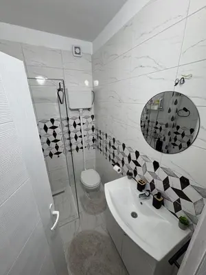 a bathroom with a toilet and a sink and a mirror at Apartman Tijana in Ruma