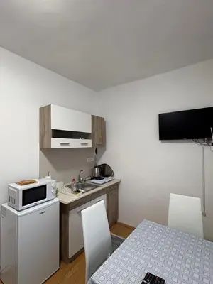 a small kitchen with a sink and a microwave at Apartman Tijana in Ruma